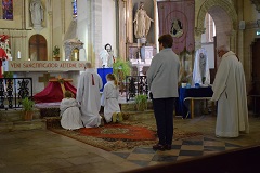 Le servant de la messe et deux enfants de choeur s’inclinent  leur tour