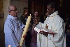 Messe pascale à Creully Le cierge pascal est porté par le prêtre