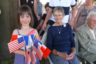 Naïs, une petite Saint loise porte des drapeaux des Alliés à côté de Sally Howie